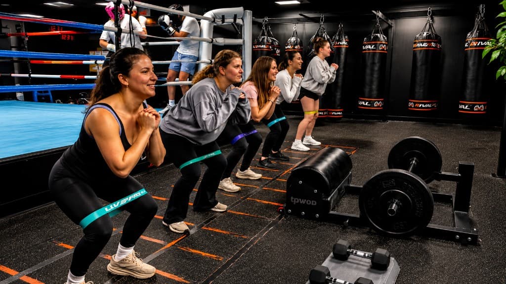 Strength & Conditioning group class with resistance band squats at SBT Boxing