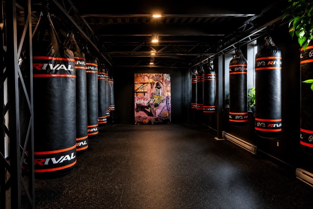Corridor of Rival heavy bags with graffiti wall art at SBT Boxing